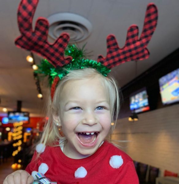 A girl wears festive Christmas antlers