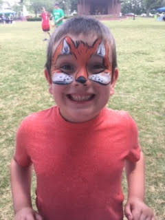 A boy with his face painted like an animal